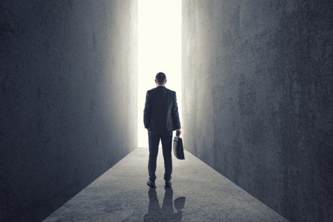 Silhouette of businessman entering giant doorway