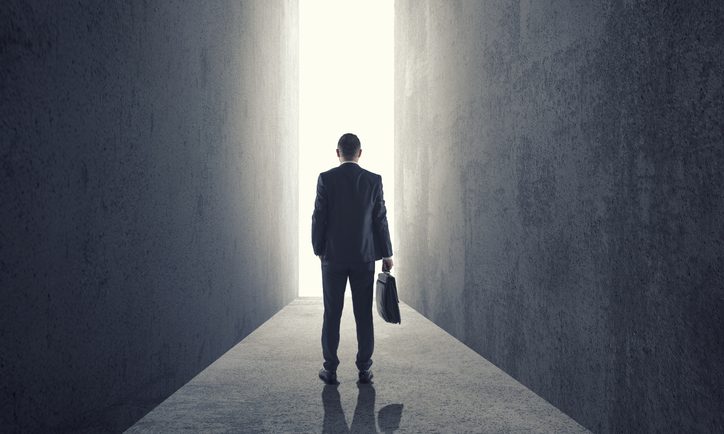 Silhouette of businessman entering giant doorway
